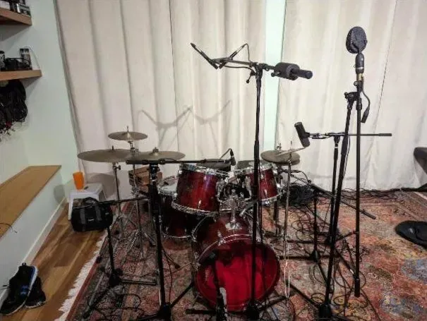 Red drum kit miked with overheads and close mics in the live room