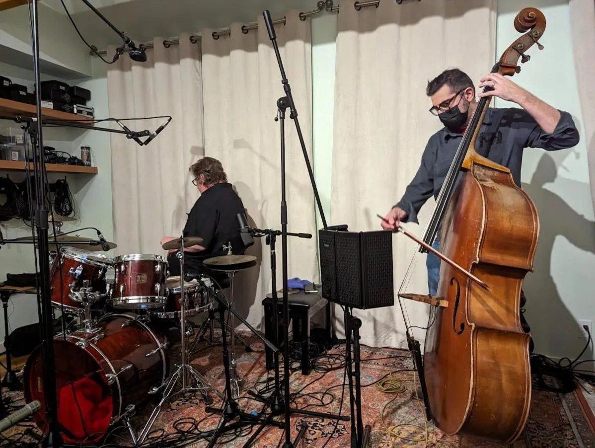 Drummer at a red kit and bassist bowing an upright bass